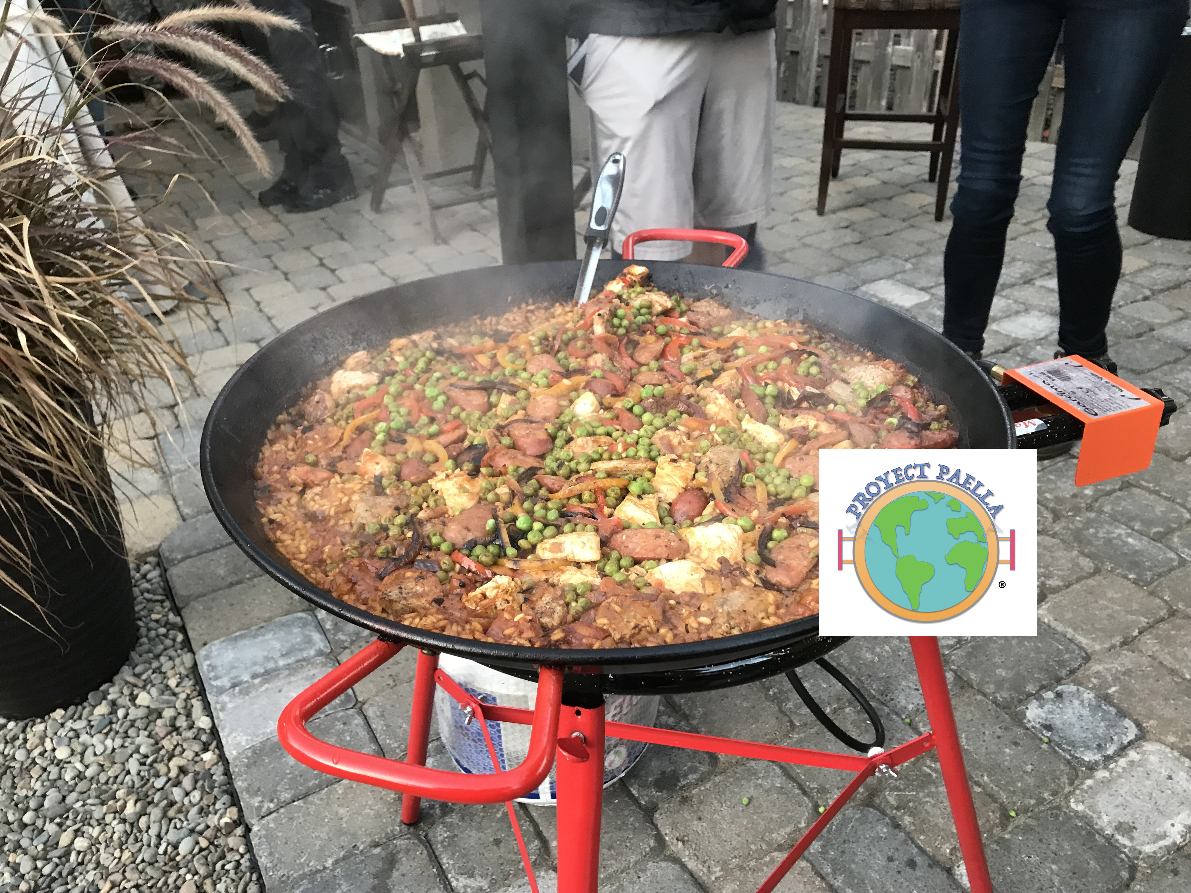 Beautiful completed paella with colorful peppers, meat, and peas